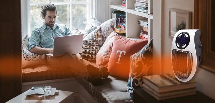 man using Toasty Heater to get warm while working on laptop